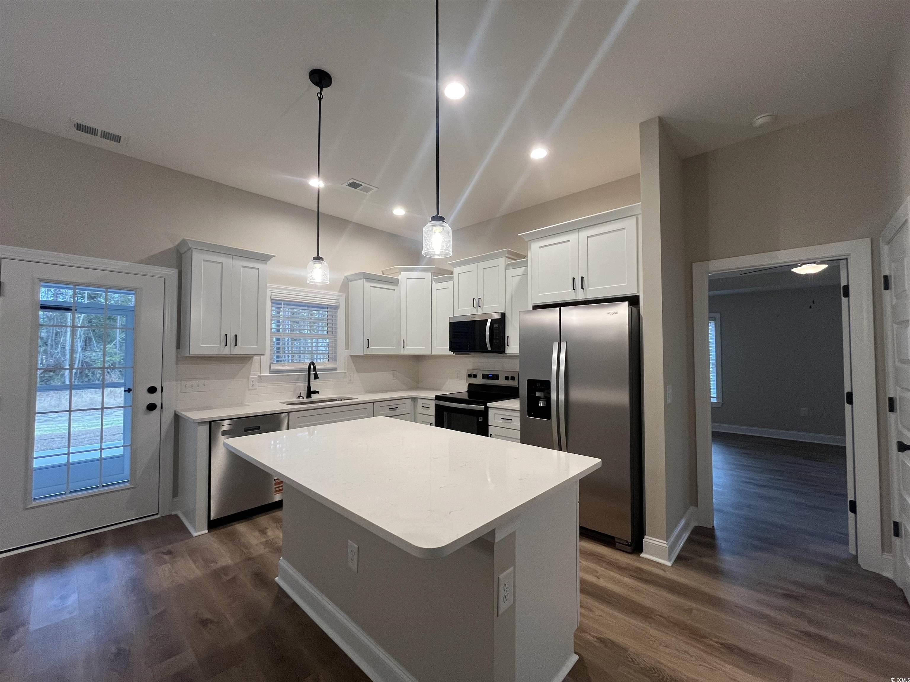 2584 Moores Mill Road Aynor, SC 29511 - Photo 3 of 14 Kitchen with stainless steel appliances, a kitchen island, white cabinetry, pendant lighting, and dark wood finished floors