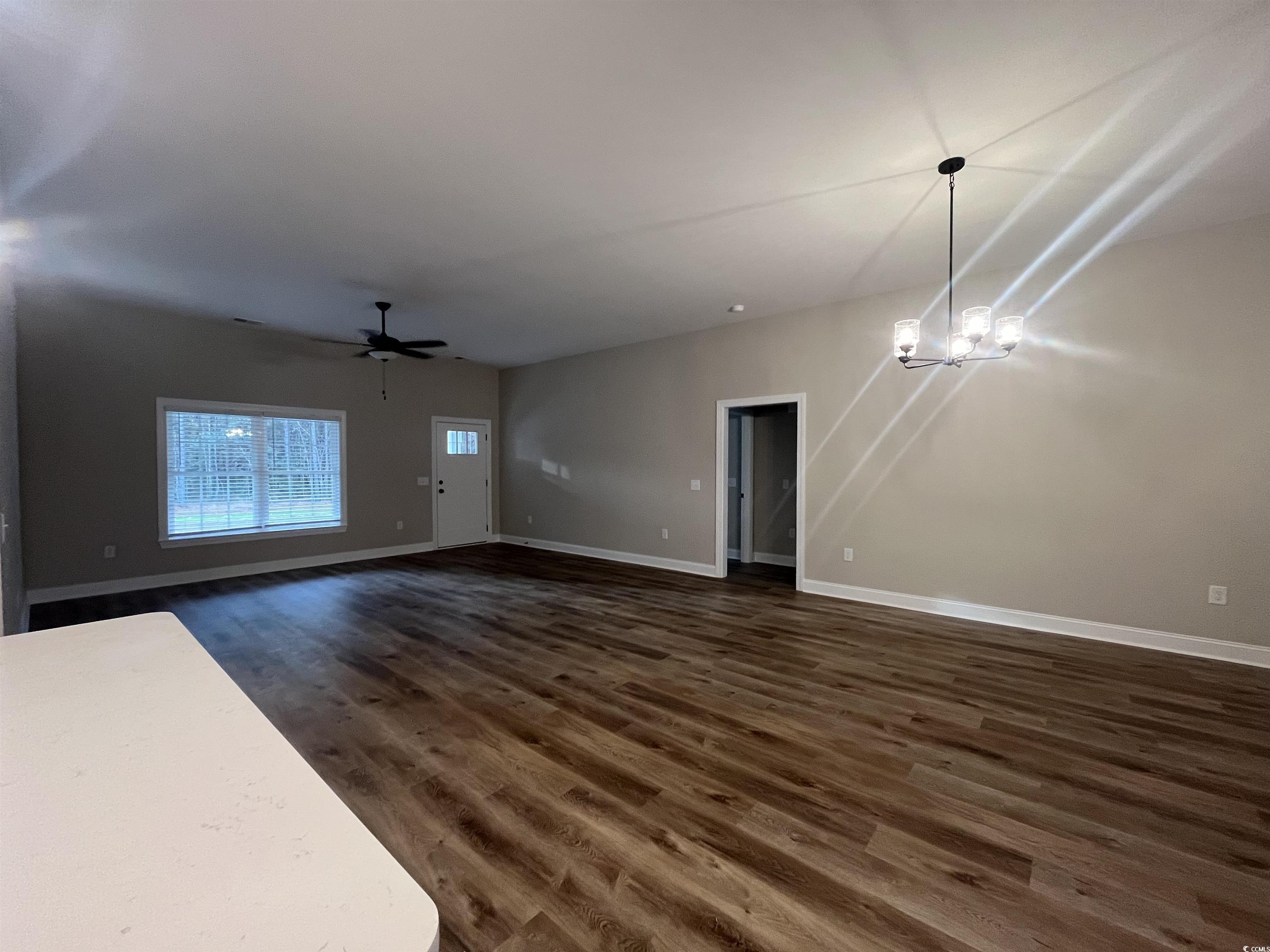 2584 Moores Mill Road Aynor, SC 29511 - Photo 4 of 14 Unfurnished living room featuring dark wood-style flooring, a chandelier, and ceiling fan