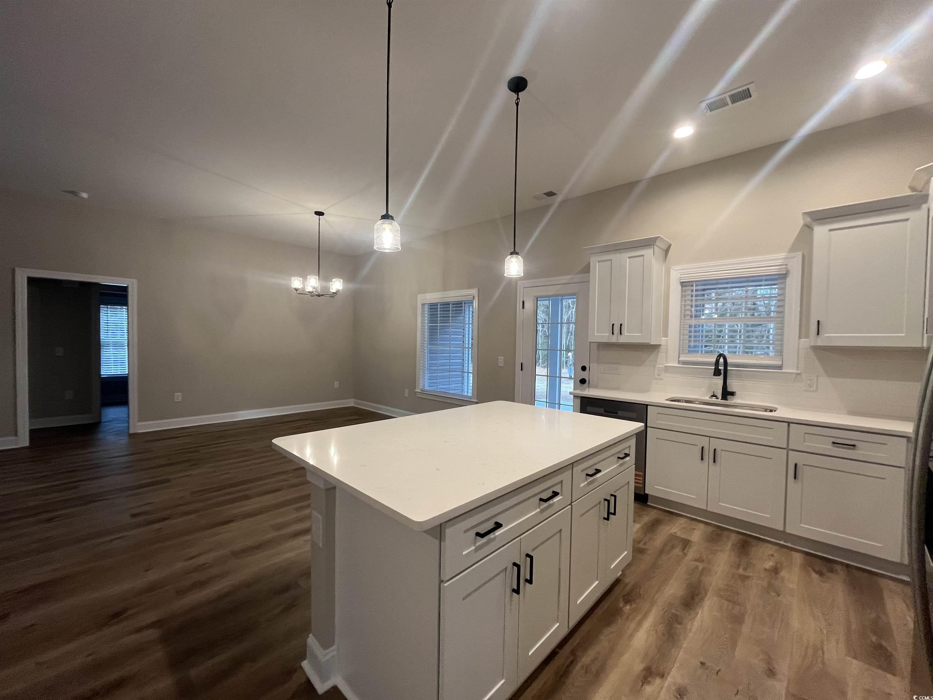 2584 Moores Mill Road Aynor, SC 29511 - Photo 6 of 14 Kitchen featuring dark wood finished floors, a kitchen island, decorative light fixtures, white cabinetry, and dishwasher