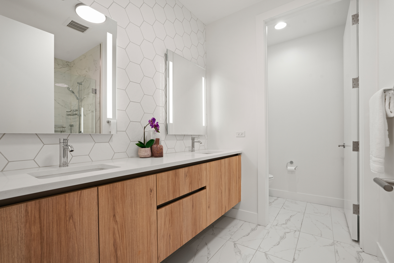 313 South Racine Avenue, Unit 4B Chicago, IL 60607 - Photo 21 of 33 a bathroom with a double vanity sink a mirror and a shower