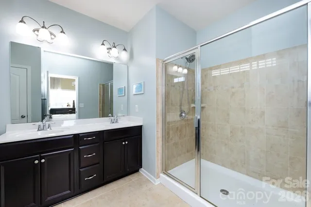 a bathroom with a double vanity sink mirror and shower