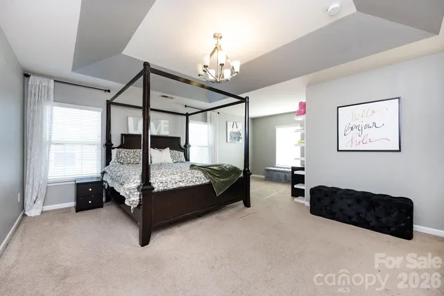 a bedroom with bed and a chandelier