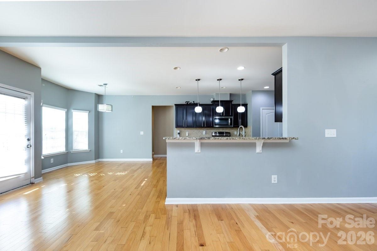 8931 Happiness Road Harrisburg, NC 28075 - Photo 8 of 27 a view of a living room with kitchen island and wooden floor