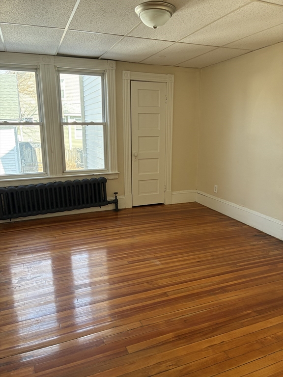 658 Sumner Avenue, Unit 1 Springfield, MA 01108 - Photo 8 of 10 an empty room with wooden floor and windows