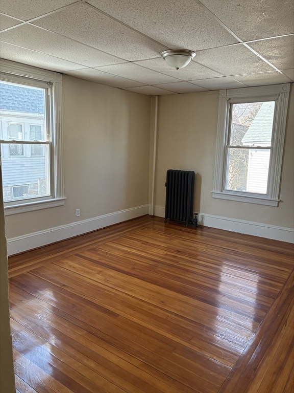 658 Sumner Avenue, Unit 1 Springfield, MA 01108 - Photo 9 of 10 an empty room with wooden floor and windows