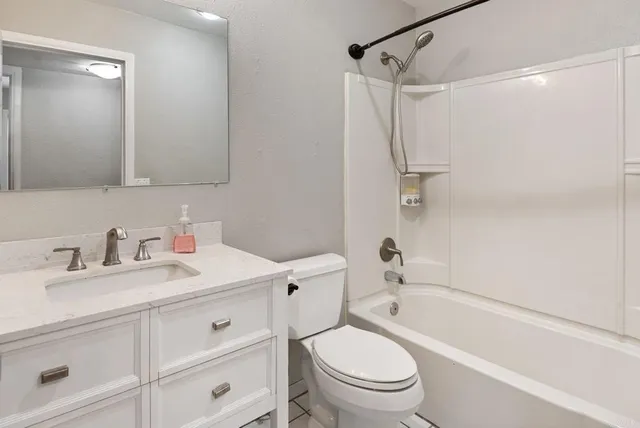 a bathroom with a granite countertop sink toilet and shower