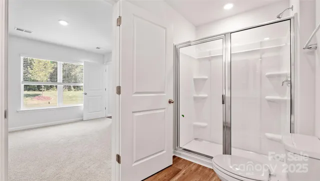 a spacious bathroom with a glass shower door and a window