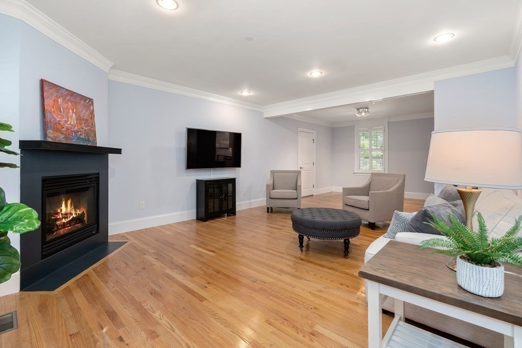 96 Crescent Street, Unit 96 Newton, MA 02466 - Photo 13 of 36 a living room with furniture a fireplace and a flat screen tv