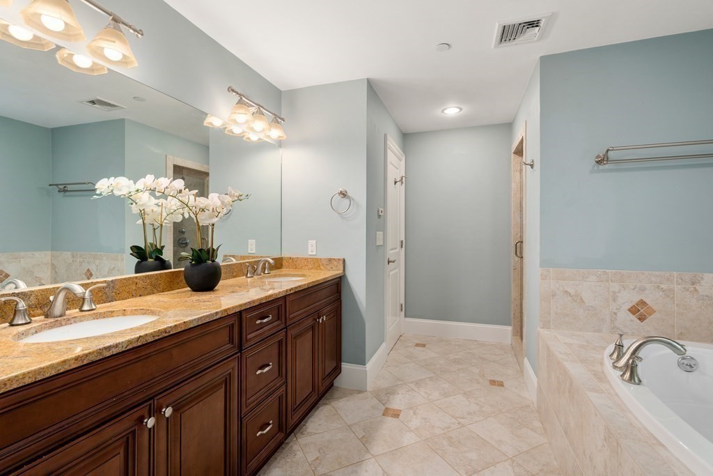 96 Crescent Street, Unit 96 Newton, MA 02466 - Photo 17 of 36 a spacious bathroom with a granite countertop sink a mirror and a bathtub