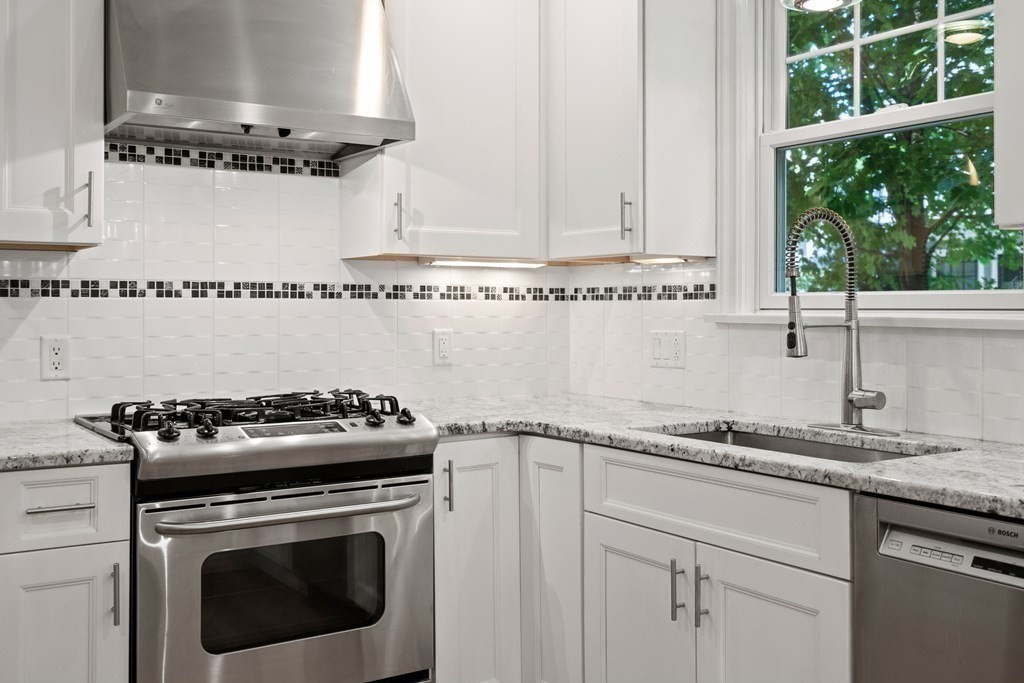 96 Crescent Street, Unit 96 Newton, MA 02466 - Photo 4 of 36 a kitchen with granite countertop a stove sink and cabinets