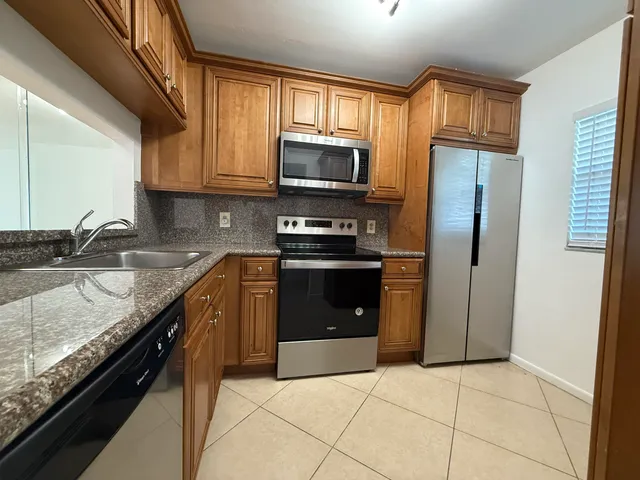 a kitchen with stainless steel appliances granite countertop a stove top oven a sink and dishwasher