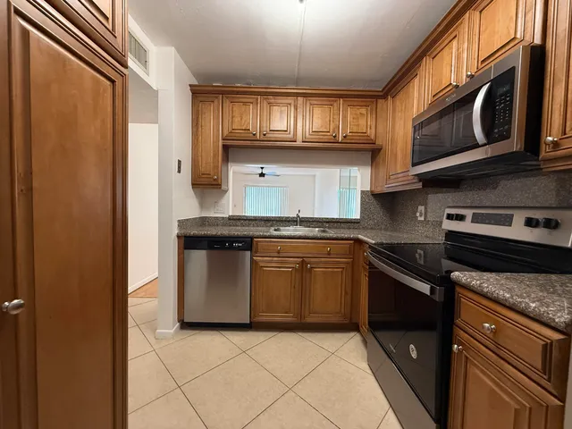 a kitchen with stainless steel appliances granite countertop a sink refrigerator and microwave