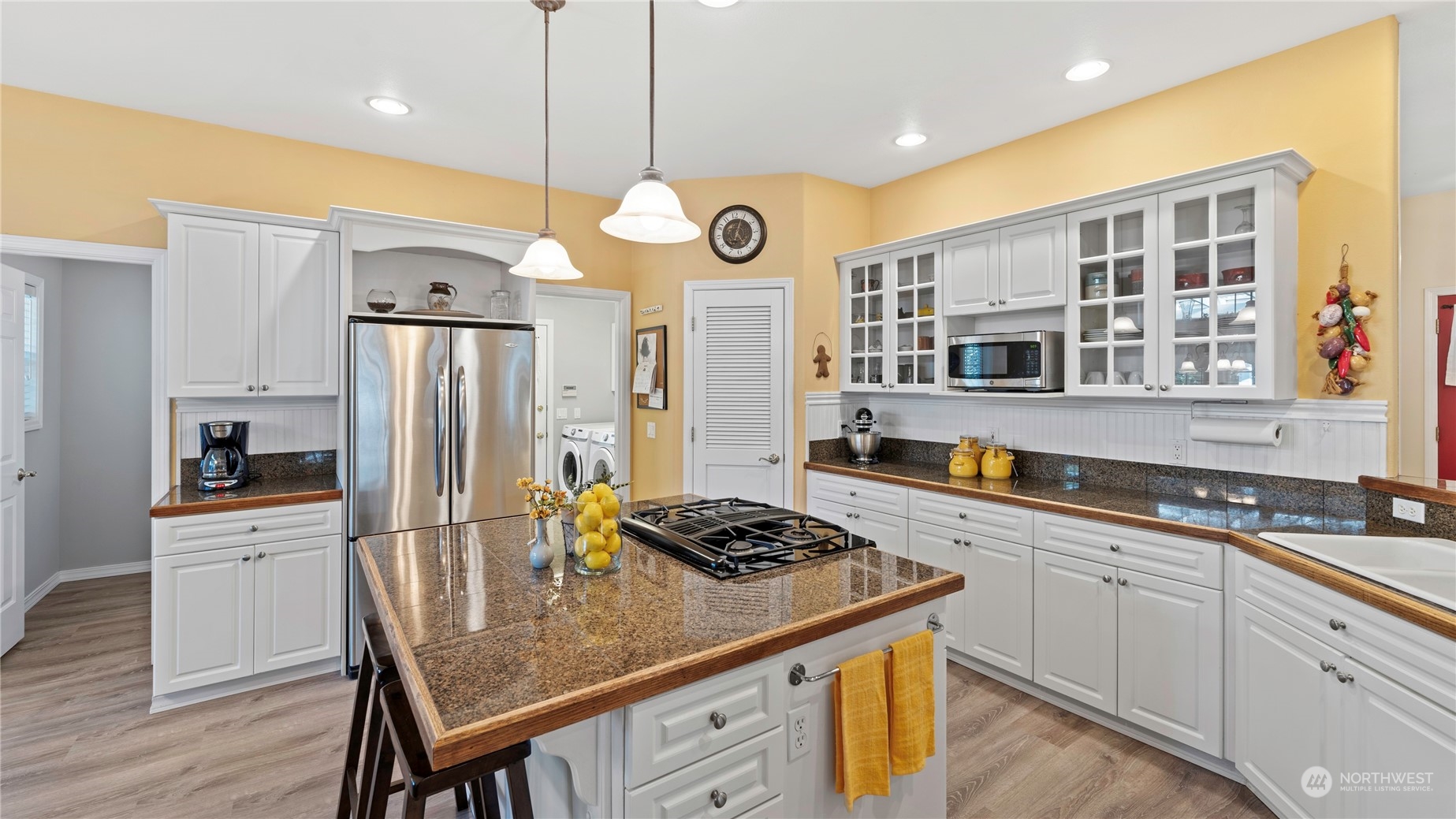 14293 Rosario Road Anacortes, WA 98221 - Photo 6 of 40 a kitchen with stainless steel appliances granite countertop a stove a sink dishwasher a refrigerator and a dining table with wooden floor