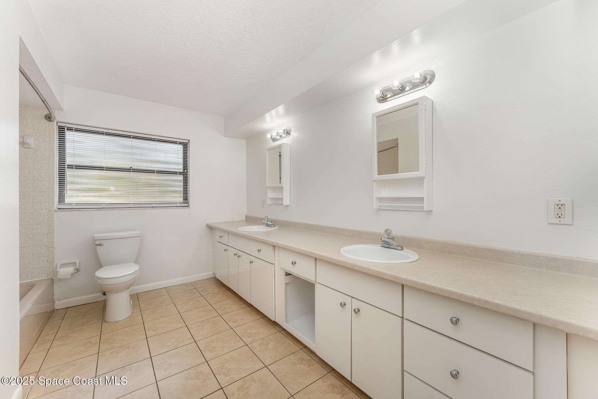 1981 Roc Rosa Drive Northeast Palm Bay, FL 32905 - Photo 20 of 29 a spacious bathroom with a granite countertop sink a toilet and a mirror