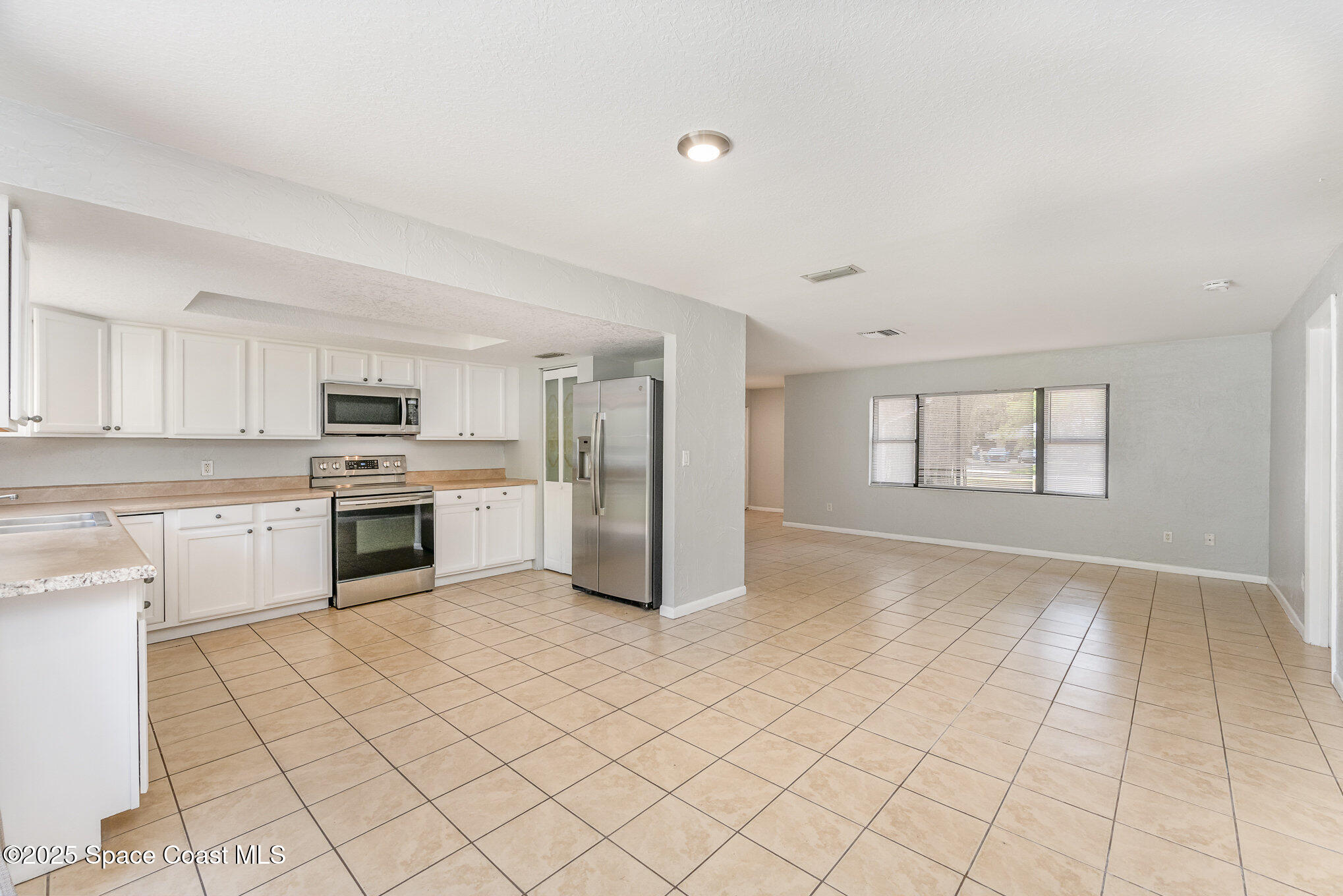 1981 Roc Rosa Drive Northeast Palm Bay, FL 32905 - Photo 6 of 29 a kitchen with a stove a sink and a refrigerator