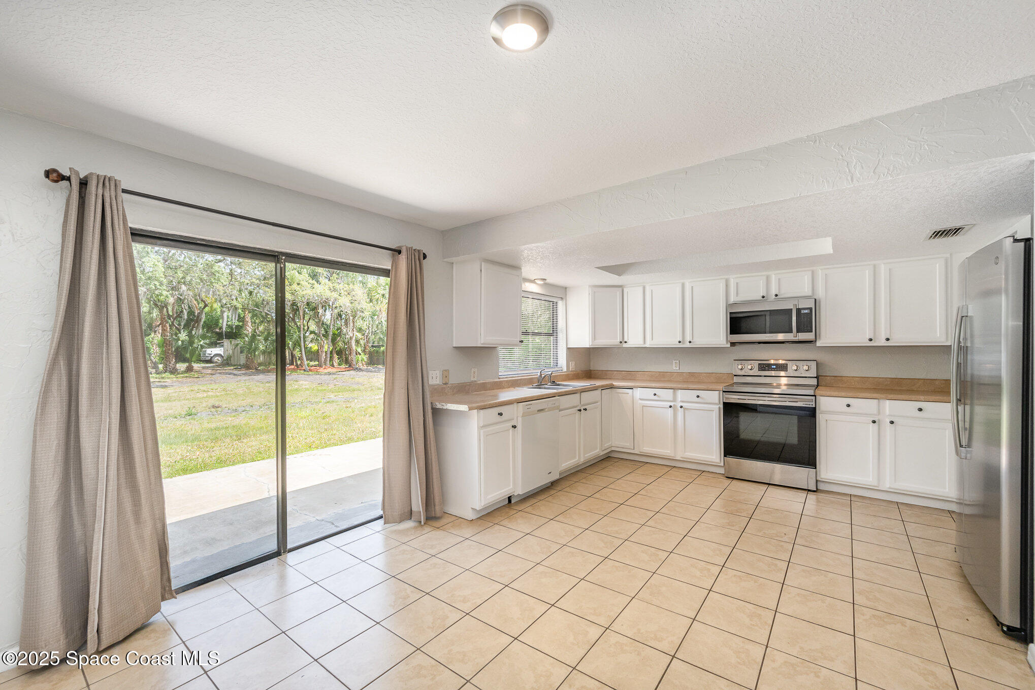 1981 Roc Rosa Drive Northeast Palm Bay, FL 32905 - Photo 7 of 29 a kitchen with granite countertop a stove top oven sink and cabinets