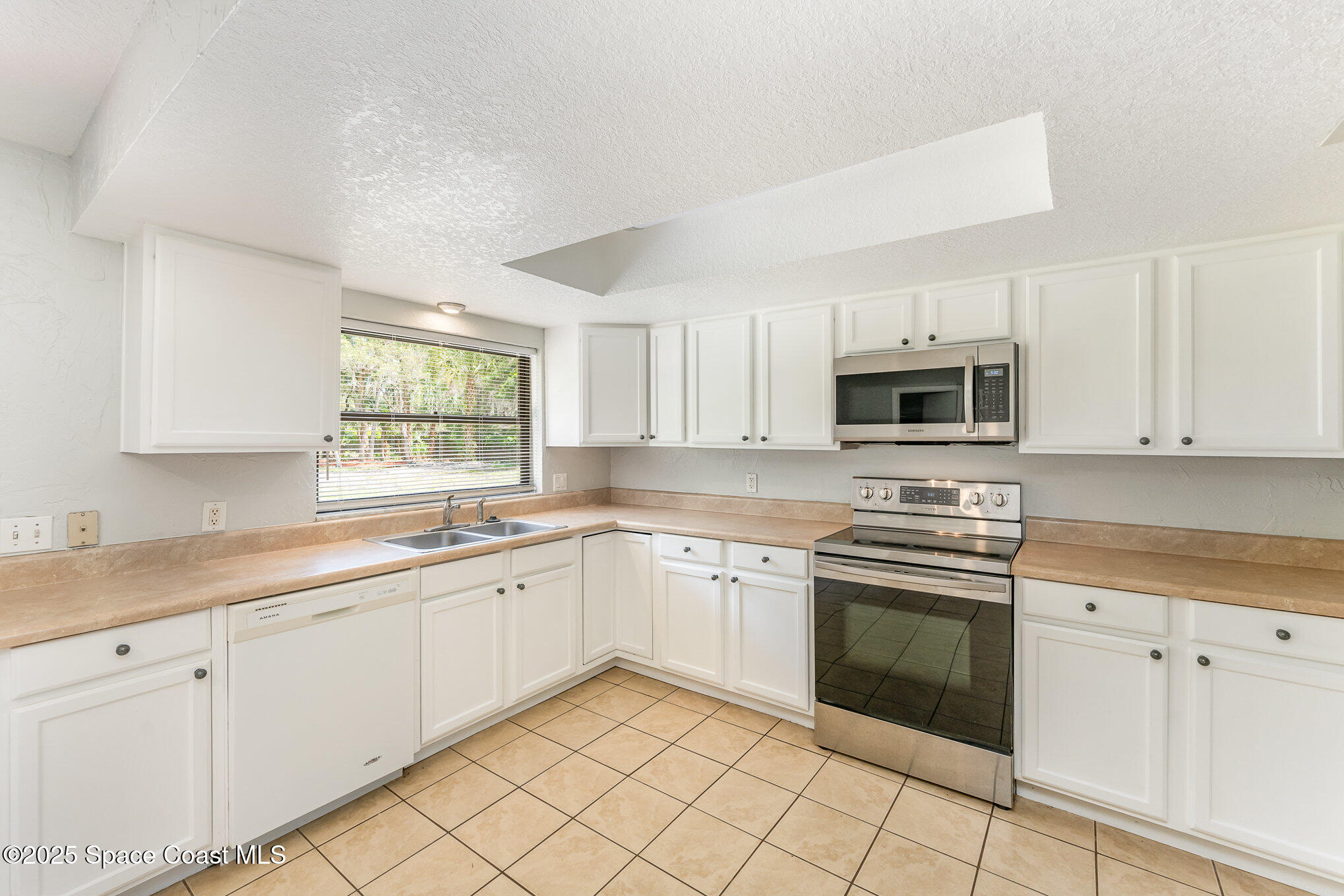 1981 Roc Rosa Drive Northeast Palm Bay, FL 32905 - Photo 10 of 29 a kitchen with white cabinets appliances and a sink