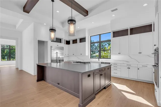 a large kitchen with stainless steel appliances kitchen island granite countertop a stove and a sink