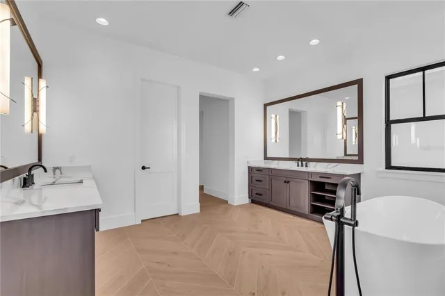 a spacious bathroom with a large tub shower and sink