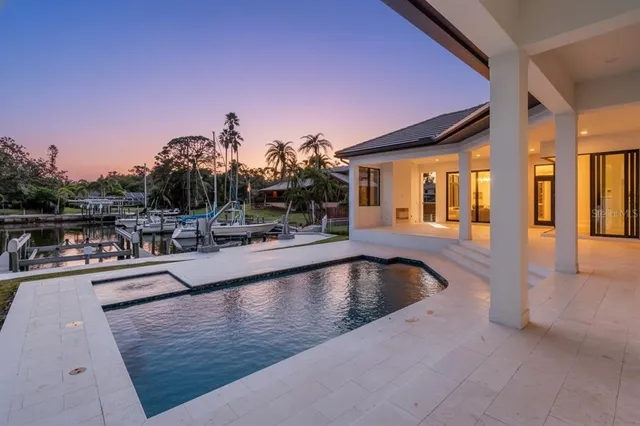 a view of a swimming pool with a patio and a yard