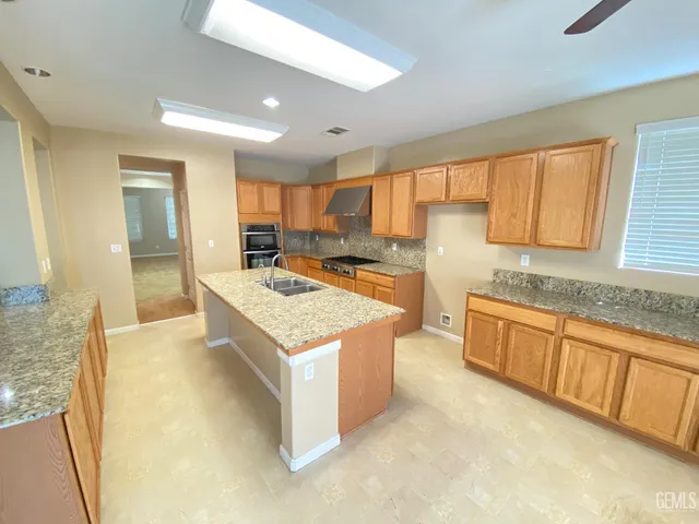 a kitchen with granite countertop a sink stove and cabinets