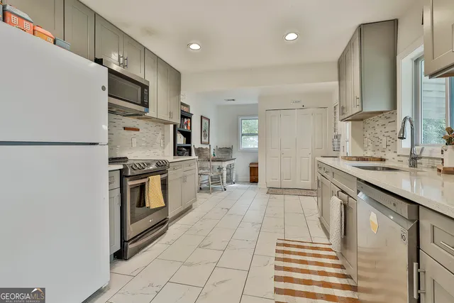 a kitchen with stainless steel appliances a refrigerator sink and microwave