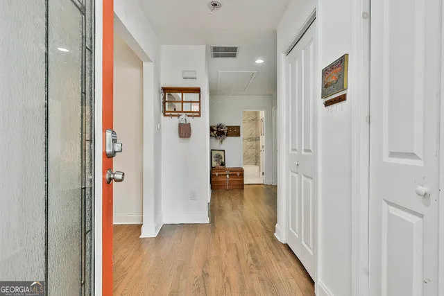 a view of a hallway with wooden floor and dining room view