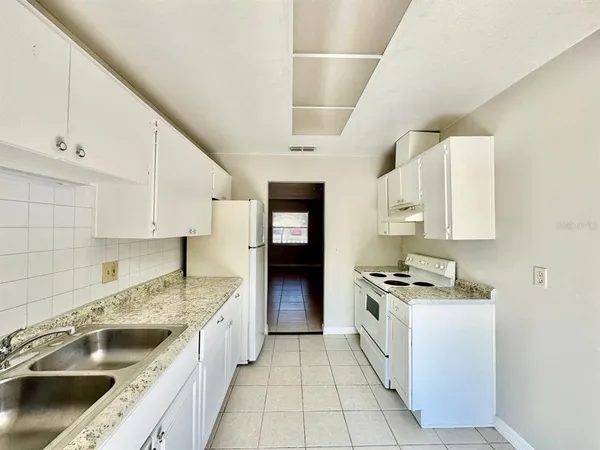 a kitchen with a stove sink and cabinets