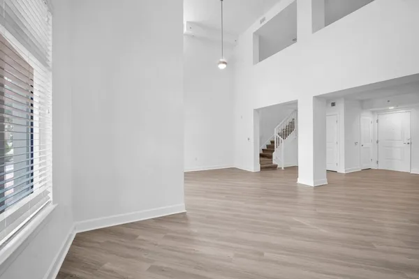 a view of empty room with wooden floor and window