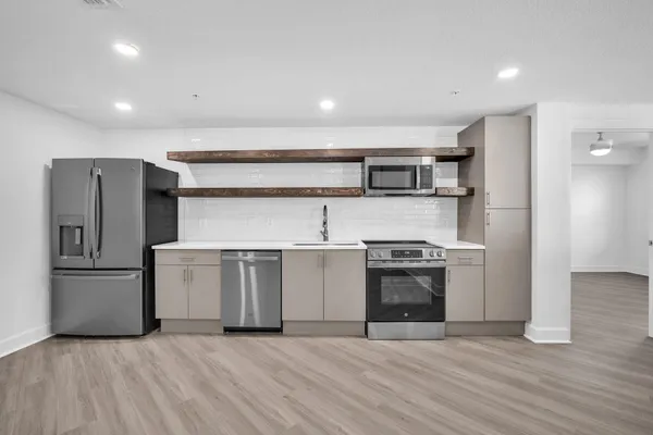a kitchen with stainless steel appliances granite countertop a refrigerator and a stove top oven