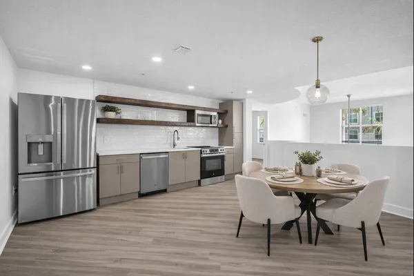 a kitchen with refrigerator cabinets and dining table