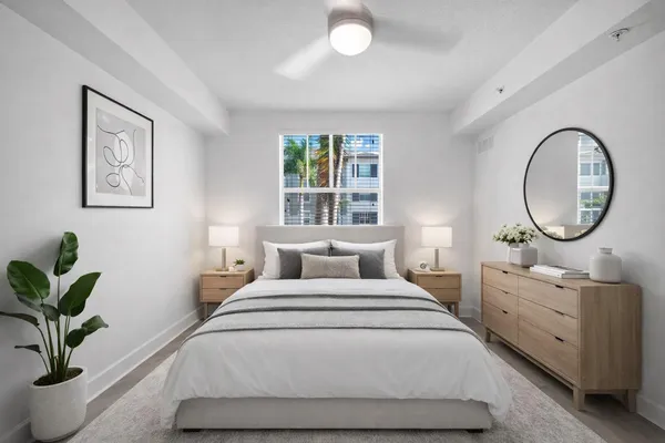 a bedroom with a large bed and a potted plant