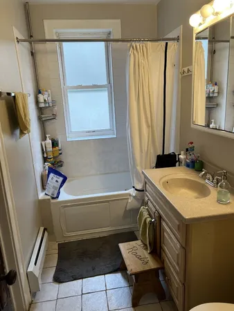 a bathroom with a tub sink and mirror