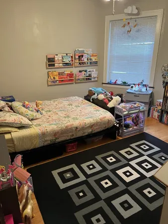 a bed sitting in a bedroom next to a window