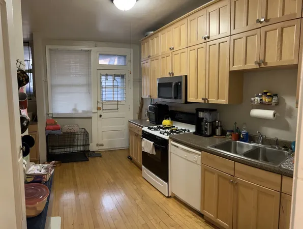 a kitchen with kitchen island granite countertop a sink cabinets and stainless steel appliances