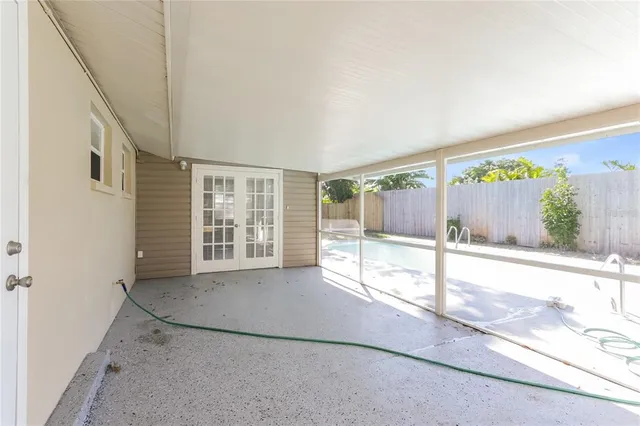 a view of an empty room with wooden floor and windows