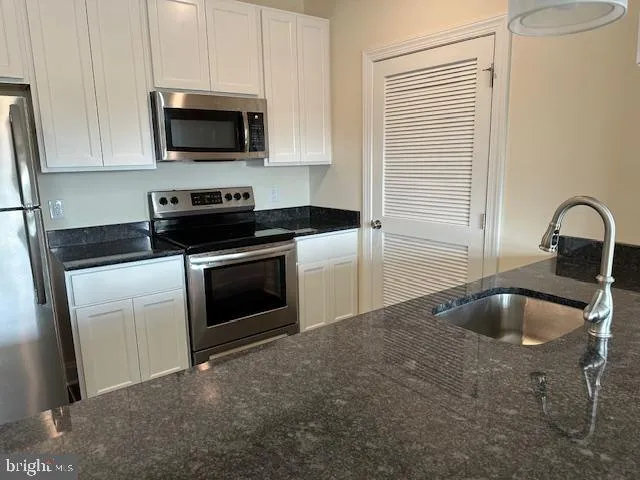 a kitchen with a sink and steel appliances