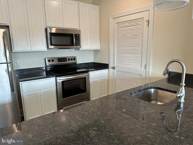 a kitchen with a sink and steel appliances