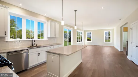 a large kitchen with stainless steel appliances granite countertop a large stove a sink dishwasher and a refrigerator with wooden floor