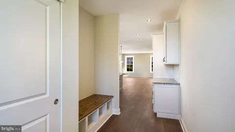 a view of hallway with cabinets and wooden floor