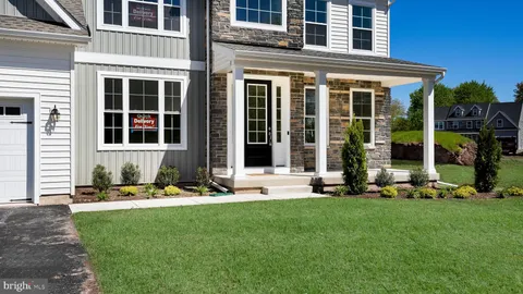 a front view of a house with a yard and brick wall