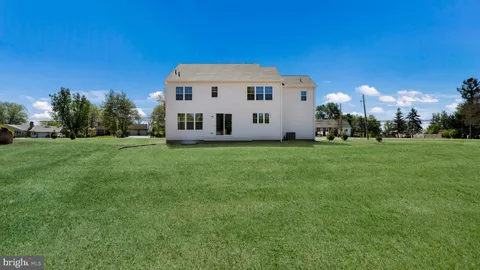 a large house with a big yard and large trees