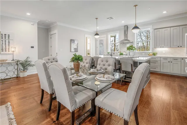a dining room with furniture a chandelier and wooden floor