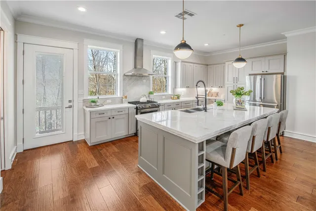 a kitchen with a sink a center island cabinets and stainless steel appliances