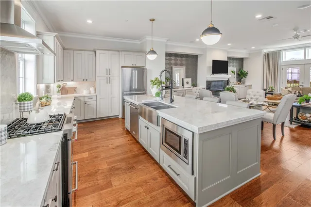 a view of a kitchen counter top space a sink stainless steel appliances and windows