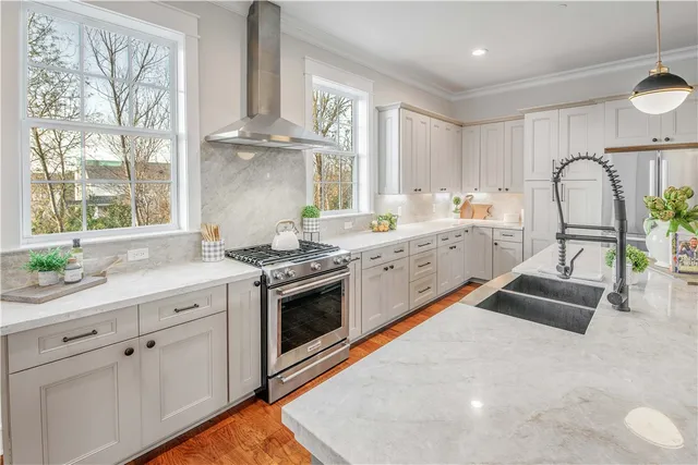 a kitchen with granite countertop a stove a sink and a refrigerator