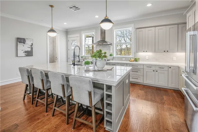 a kitchen with stainless steel appliances granite countertop wooden floor dining table and chairs