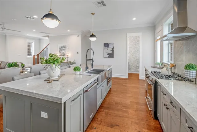 a kitchen with stainless steel appliances a stove a sink and a large window