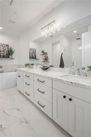a spacious bathroom with a double vanity sink mirror and bathtub