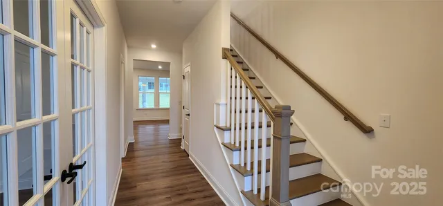 a view of a hallway with wooden floor and entryway